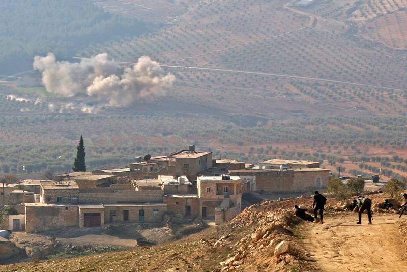 A picture taken on February 5, 2018, on a mountain on the Syrian-Turkish border, north of Azaz, shows Turkish-backed Syrian rebels watching as smoke billows in the village of al-Amud following artillery shelling.
Turkey launched operation "Olive Branch" on January 20 against the Syrian Kurdish People's Protection Units (YPG) militia in Afrin, supporting Syrian opposition fighters with ground troops and air strikes. / AFP PHOTO / Saleh ABO GHALOUN