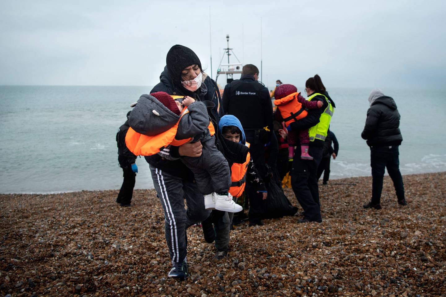 A migrant and her children after being helped ashore from an RNLI  lifeboat at a beach in Dungeness, on the south-east coast of England last month. AFP