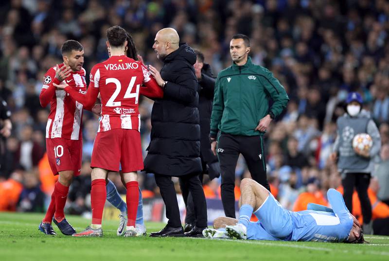 Atletico Madrid's Angel Correa with City manager Pep Guardiola as Jack Grealish lies on the ground. Reuters