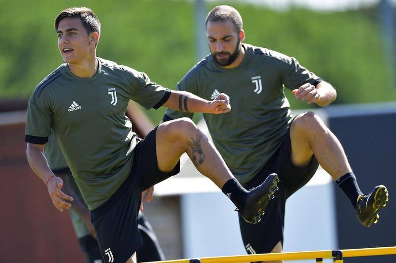 Juventus' forward Paulo Dybala (L) from Argentina and Juventus' forward Gonzalo Higuain from Argentina take part in a training session on the eve of the UEFA Champions League football match Barcelona vs Juventus on September 11, 2017 in Vinovo, near Turin. / AFP PHOTO / Marco BERTORELLO