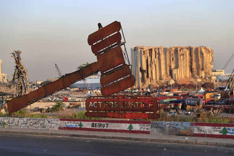 A monument that represents justice stands in front of towering grain silos that were gutted in the massive August 2020 explosion at the port that killed more than 200 people in Beirut. AP Photo