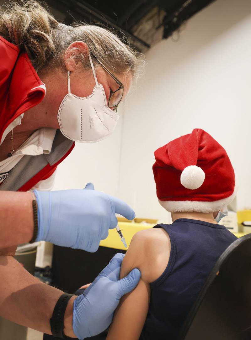 A boy wearing a Christmas hat is vaccinated in a shopping centre near Hamburg, Germany. AP