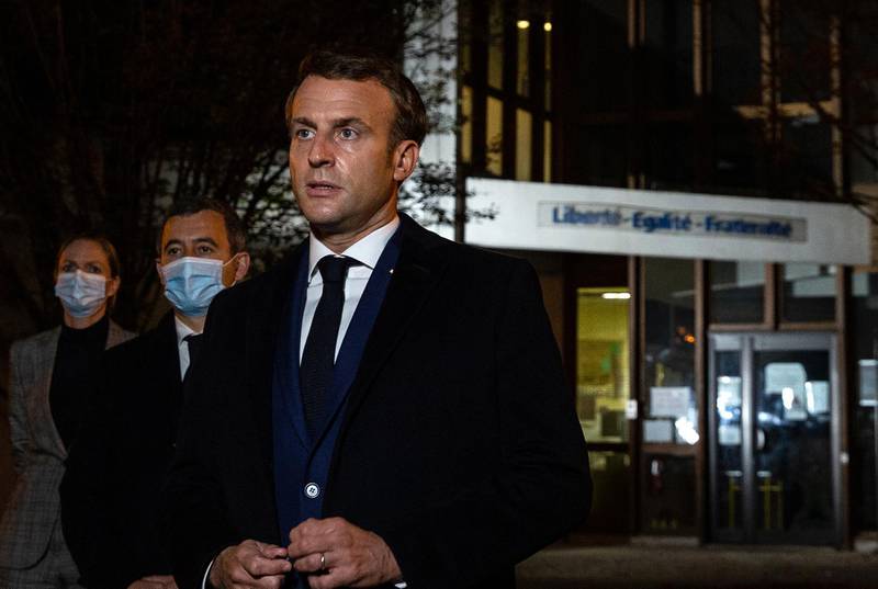French President Emmanuel Macron, flanked by French Interior Minister Gerald Darmanin, speaks to the press in front of a middle school in Conflans Saint-Honorine. AFP, Pool