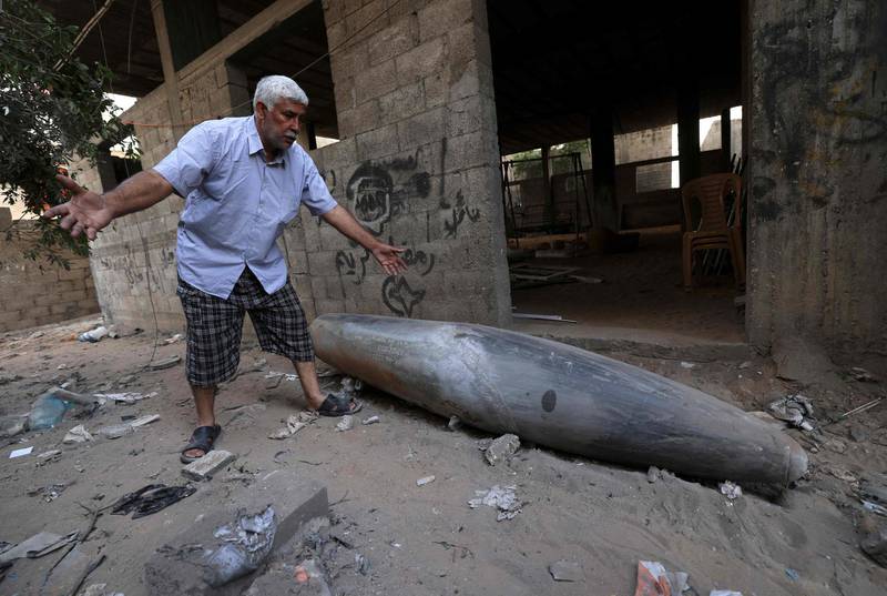 A Palestinian man reacts as he looks at an unexploded bomb dropped by an Israeli F-16 warplane on Gaza City's Rimal neighbourhood on May 18. AFP