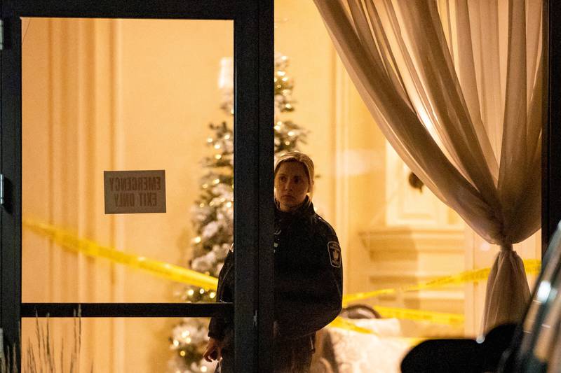 A police officer looks out from the lobby after a fatal mass shooting at a condominium building in the Toronto suburb of Vaughan, Ontario, Canada December 19, 2022.   REUTERS / Carlos Osorio     TPX IMAGES OF THE DAY