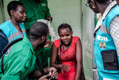 TOPSHOT - An injured woman receives medical attention at the scene of an explosion at a hotel complex in Nairobi's Westlands suburb on January 15, 2019, in Kenya. A huge blast followed by a gun battle rocked an upmarket hotel and office complex in Nairobi on January 15, 2018, causing casualties, in an attack claimed by the Al-Qaeda-linked Shabaab Islamist group. / AFP / Luis TATO AND Luis TATO
