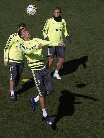 Real Madrid’s Cristiano Ronaldo heads the ball next to teammate Pepe (R) during training session prior to “Clasico” against Barcelona. REUTERS/Sergio Perez