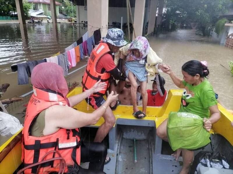 Rescuers assist an elderly person into a raft in a flooded village in Sigma, Capiz province, Philippines. EPA