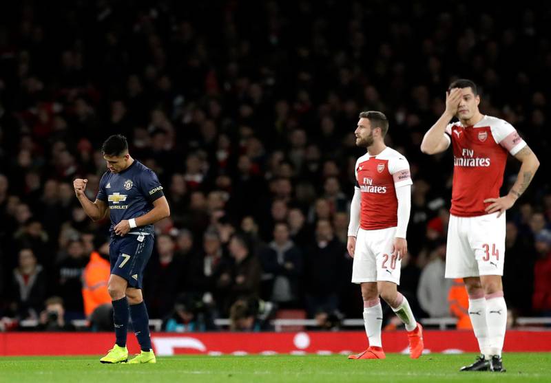 Manchester United's Alexis Sanchez, left, celebrates after scoring his side's opening goal during the English FA Cup fourth round soccer match between Arsenal and Manchester United at the Emirates stadium in London, Friday, Jan. 25, 2019. (AP Photo/Matt Dunham)