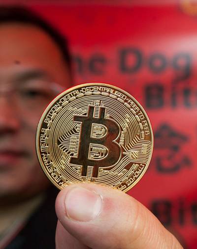 epa06520674 Crypto-currency trader Eddie Chou promotes commemorative Year of the Dog souvenir Bitcoin medals ahead of the Chinese New Year of the Dog which begins on 16 February 2018, at a Chinese New Year Fair in Victoria Park, Causeway Bay, Hong Kong, China, 13 February 2018.  EPA/ALEX HOFFORD