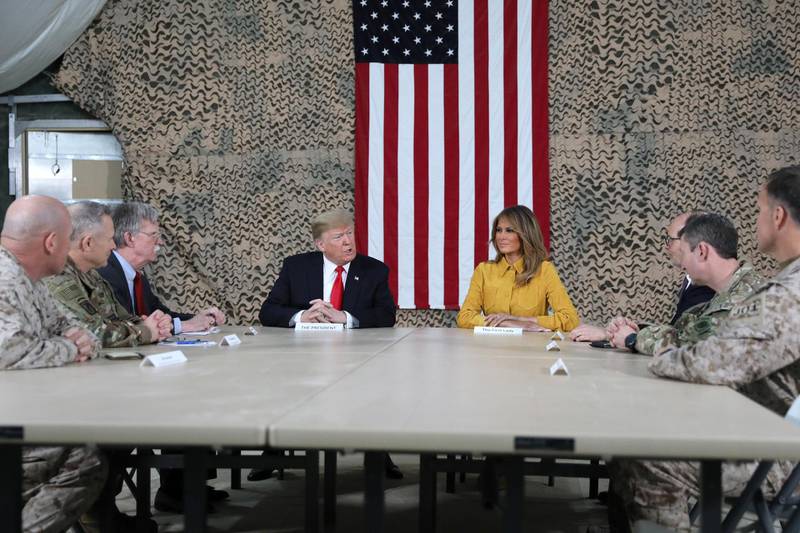US President Donald Trump, flanked by National Security Adviser John Bolton, first lady Melania Trump and US Ambassador to Iraq Doug Silliman, meets political and military leaders during an unannounced visit to Al Asad Air Base, Iraq. Reuters
