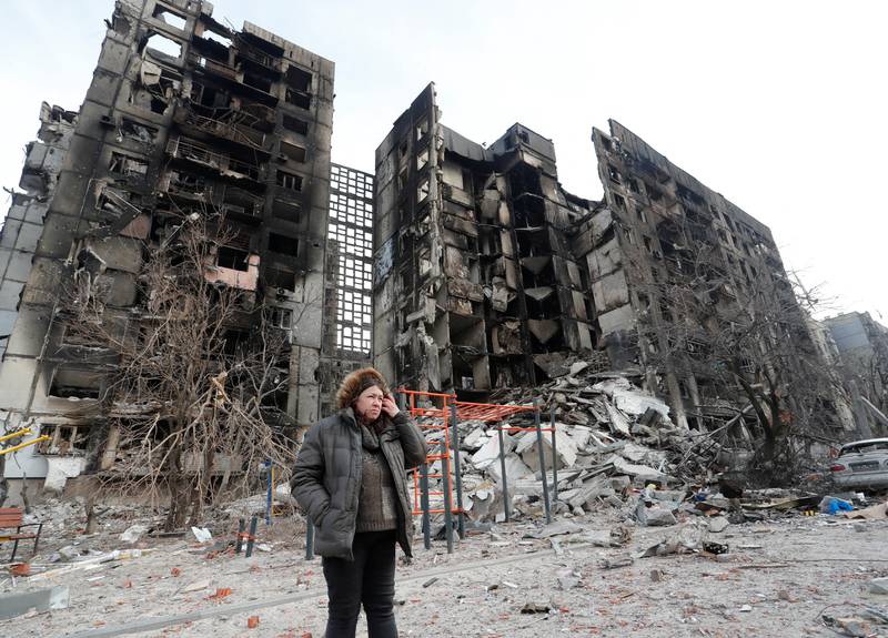 Nurse Svetlana Savchenko, 56, stands next to her bombed-out apartment building in the besieged southern port city of Mariupol, Ukraine, on March 30. Reuters