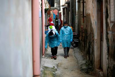 Palestinian volunteers spray disinfectant a street at Al Shati refugee camp in Gaza City. AFP