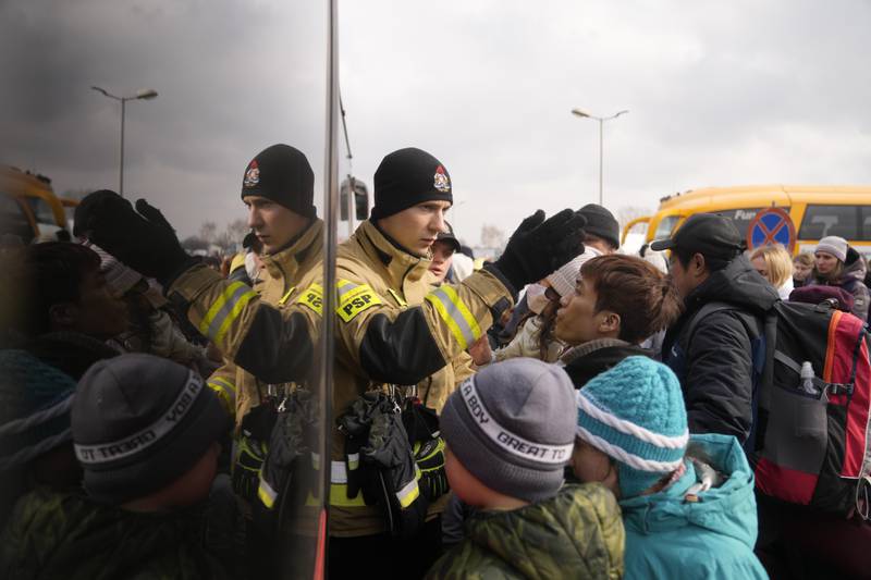 People fleeing from Ukraine queue to board on a bus at the border crossing in Medyka, Poland. AP