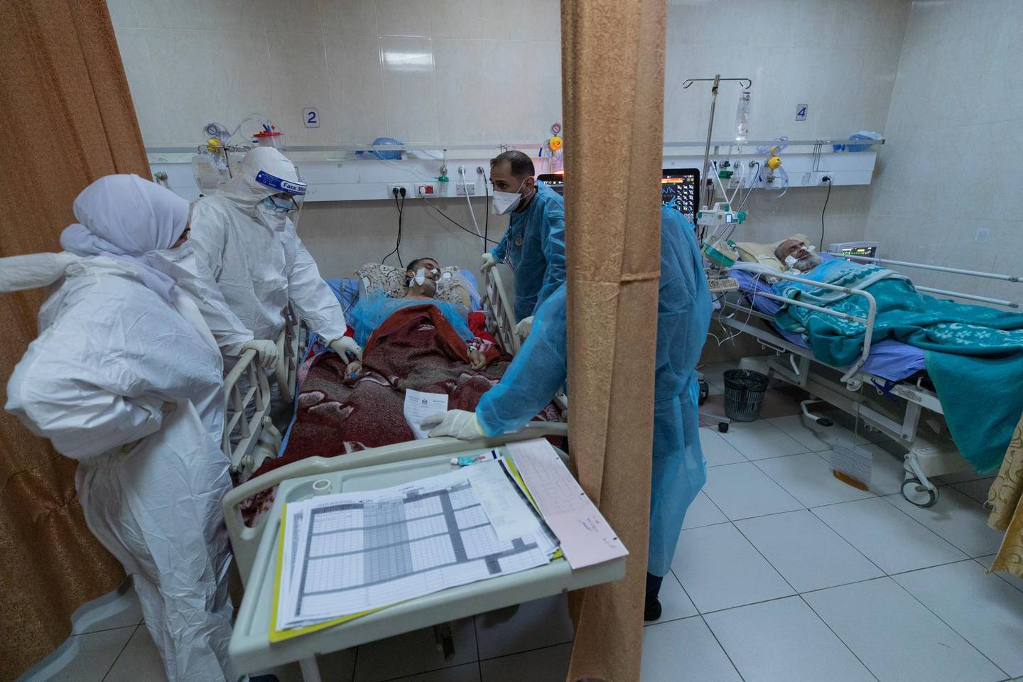Medical staffers attend a Palestinian COVID-19 patient at the intensive care unit, in the Palestine Medical Complex, in the West Bank city of Ramallah, Thursday, Jan. 28, 2021. (AP Photo/Nasser Nasser)
