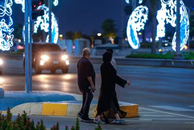 Abu Dhabi, United Arab Emirates, July 19, 2020.     Eid Al Adha Corniche lights.  A couple crosses the Corniche.Victor Besa  / The NationalSection: NAReporter: