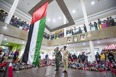 DUBAI, UNITED ARAB EMIRATES - Abdullah Ali Almansoori and Humaid Mohammed Alnuaimi saluting the flag with the students from Gems Royal Dubai School celebrating UAE flag day.  Leslie Pableo for The National fro Anam Rizvi’s story