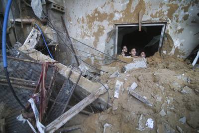 Palestinian children sit among the rubble of a house in Rafah destroyed by Israeli air strikes on the Gaza Strip. AP
