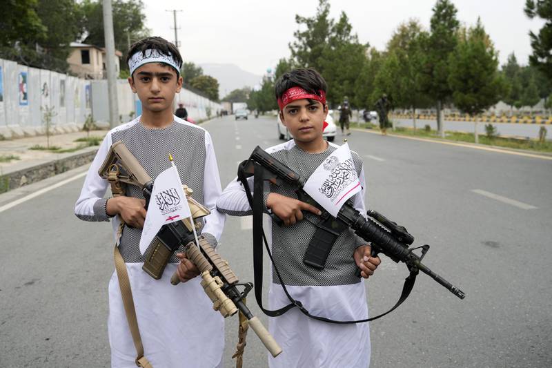 Afghan boys hold weapons as they join the celebrations. AP