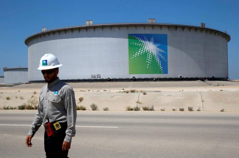 FILE PHOTO: An Aramco employee walks near an oil tank at Saudi Aramco's Ras Tanura oil refinery and oil terminal in Saudi Arabia, May 21, 2018. REUTERS/Ahmed Jadallah/File Photo