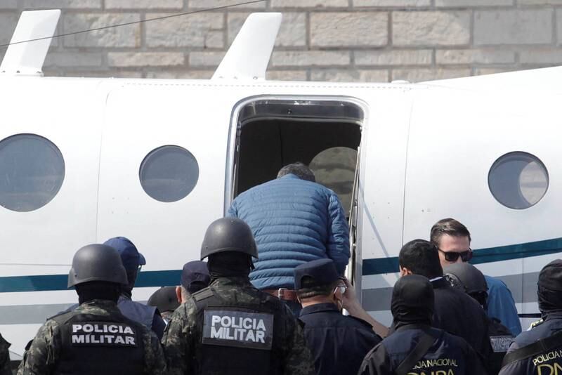 Juan Orlando Hernandez boards a plane to the US during his extradition. Reuters