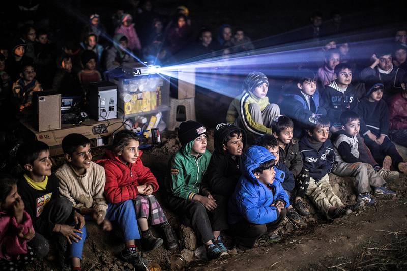Refugee children watching movie in a cenima made only for them at the refugee camp at the border. Eidomeni is now worldwide known for a sad reason. 12.500 refugees among them children, old women and men are stuck on the borders between Greece and Macedonien.