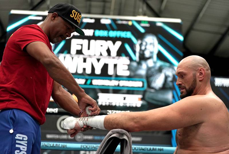 Tyson Fury has his hands wrapped by trainer SugarHill Steward during the media day at Wembley ahead of his title fight against Dillian Whyte. PA