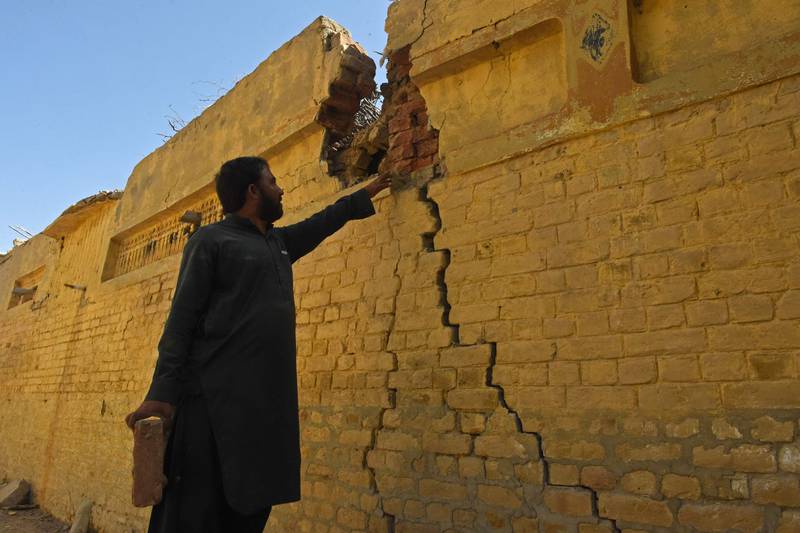 A resident checks a damaged wall of his house in the quake-hit district of Harnai.  AFP