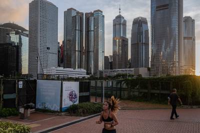A jogger runs as buildings stand in the Central district in Hong Kong, China, on Monday, June 22, 2020. The U.S. Senate approved a bipartisan measure on June 25 that would penalize banks doing business with Chinese officials involved in the national security law the country is seeking to impose on Hong Kong. Photographer: Billy H.C. Kwok/Bloomberg