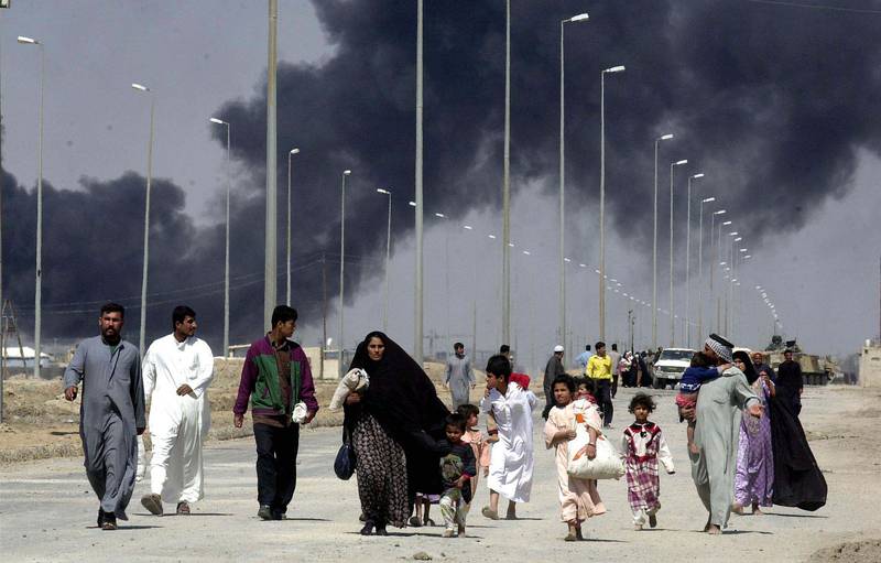 Residents flee the burning town of Basra in March 2003 as US bombing continues to remove Saddam Hussein from power. Getty Images