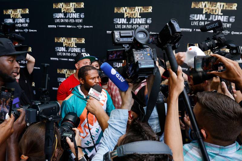 Floyd Mayweather reacts as Jake Paul takes his hat during a media day for Mayweather's fight against Logan Paul at Hard Rock Stadium. AFP