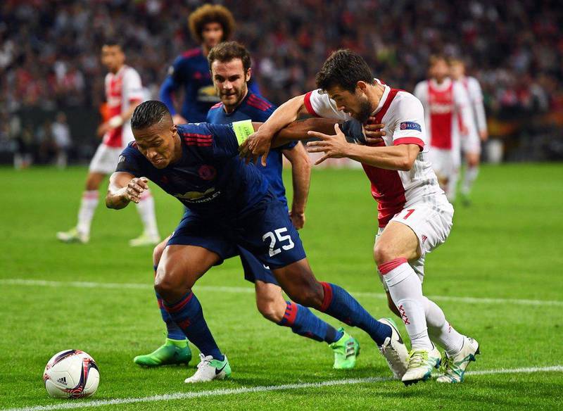 Manchester United full-back Antonio Valencia holds off the challenge of Ajax midfielder Amin Younes. Georgi Licovski / EPA