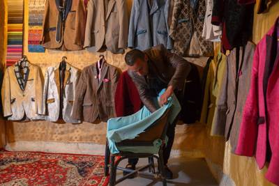 Ali Sarsour is surrounded by his suits made of leftover fabric from chairs at his home in Amman. Reuters