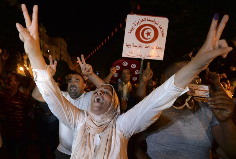Supporters of President Kais Saied rejoice on Habib Bourguiba Avenue after early estimates point to an almost certain victory, in Tunis. AFP