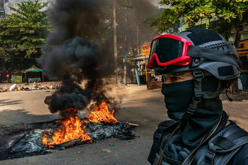 Protesters set fire to tyres on a road to slow the progress of security forces in Yangon. Getty Images