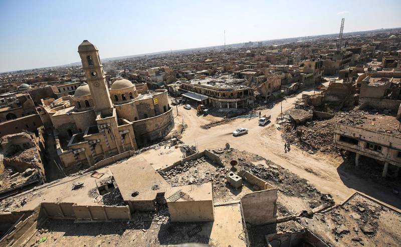 (FILES) This file photo taken on March 14, 2018 shows a view of destruction surrounding the Roman Catholic Church of Our Lady of the Hour (L) in the old city of Mosul, eight months after it was retaken by Iraqi government forces from the control of Islamic State (IS) group fighters. An exhibition opens at the Institute of the Arab World (IMA) in Paris showing the "millennia cities" resuscitated by the miracle of 3D, from Mosul to Aleppo. / AFP / AHMAD AL-RUBAYE
