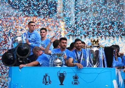 Manchester City's Phil Foden with the Champions League trophy, Aymeric Laporte with the Emirates FA Cup and Ruben Dias with the Premier League trophy. PA 