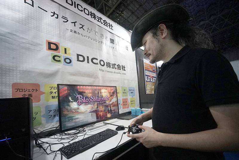 Game creator Koji Igarashi plays a new game called "Bloodstained: Ritual of the Night" while speaking during an interview at the Tokyo Game Show. Eugene Hoshiko / AP Photo