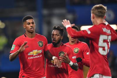Manchester United's English striker Marcus Rashford, left, celebrates with teammates after scoring his team's first goal. AFP