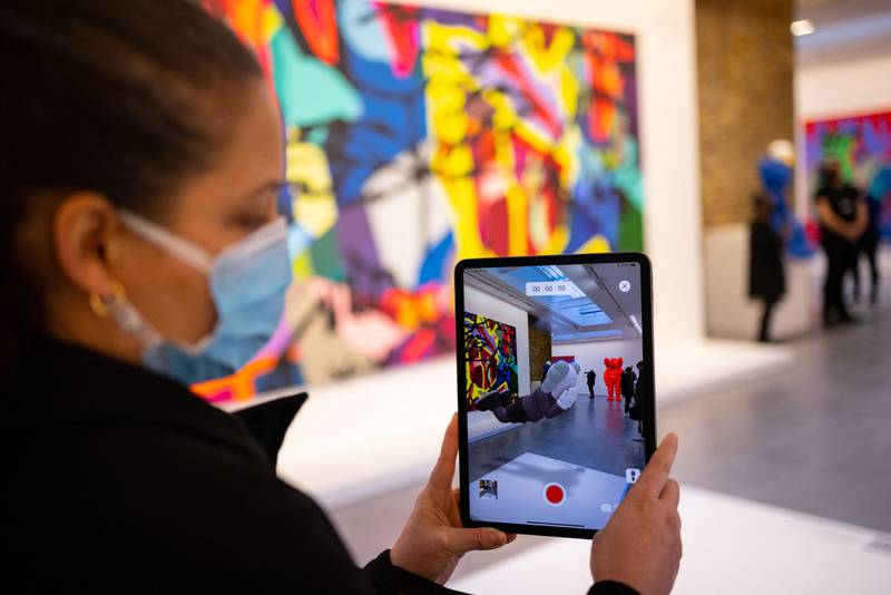 A staff member uses the Acute Art app to display an augmented reality artwork. AFP