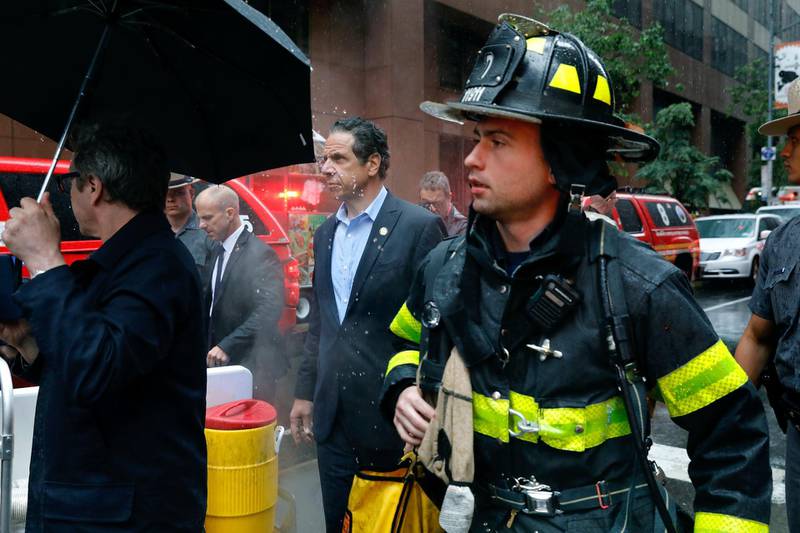 New York Gov. Andrew Cuomo, center, and first responder personnel walk near the scene. AP Photo