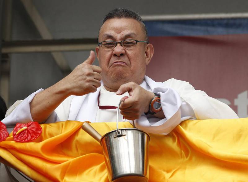 A priest gestures after he ran out of holy water as he prepares for Black Nazarene in Manila. Erik De Castro / Reuters