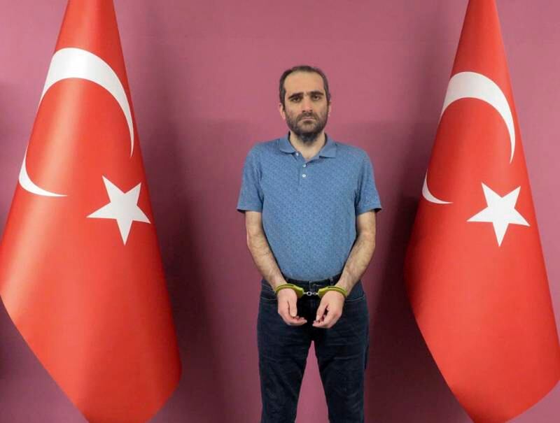 Selahattin Gulen, a nephew of U.S.-based Muslim cleric Fethullah Gulen, stands between Turkish flags in this photo provided by Turkish intelligence service, on Monday, May 31, 2021, in Ankara, Turkey. Turkish agents have captured Selahattin Gulen in an overseas operation and have brought him to Turkey where he faces prosecution, Turkey's state-run news agency said Monday. Gulen, who was wanted in Turkey on charges of membership in a terror organization, was seized in an operation by Turkey's national spy agency, MIT, Anadolu Agency reported. (Turkish Intelligence Service via AP)