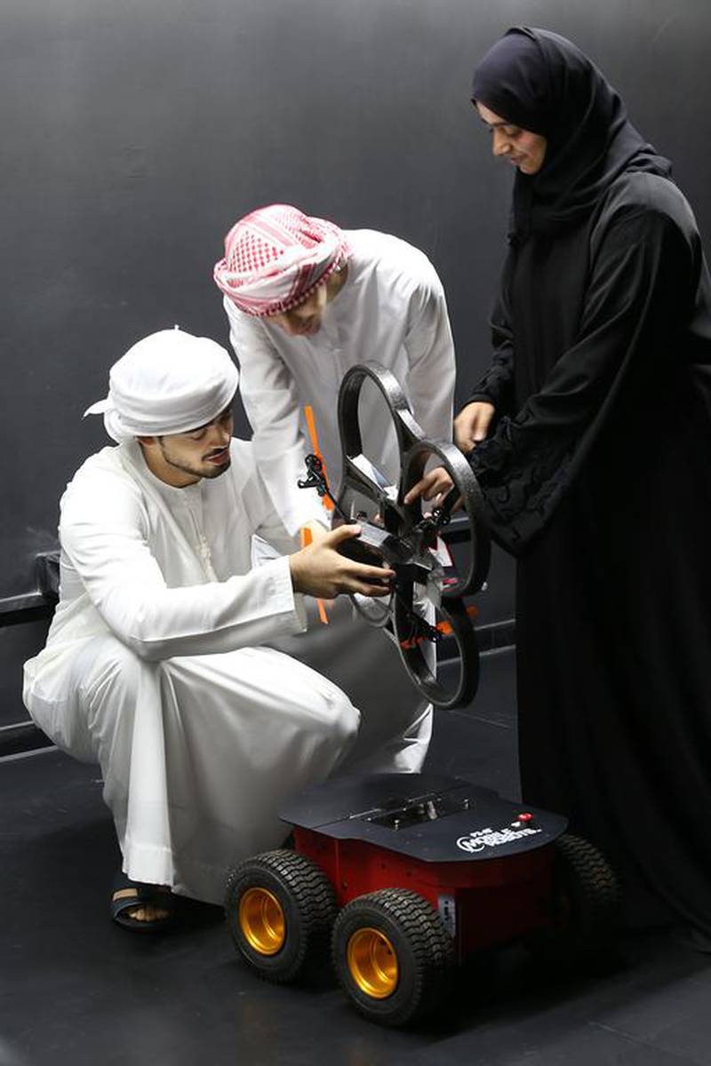 (From left) Ali Al Nuwais, 21, Ibraheem Al Ali, 23 and Fatima Al Hameli, 21, all aerospace engineering students at Khalifa University, check out a drone in their new space lab on Wednesday, October 7, 2015, in Abu Dhabi.    Delores Johnson / The National
