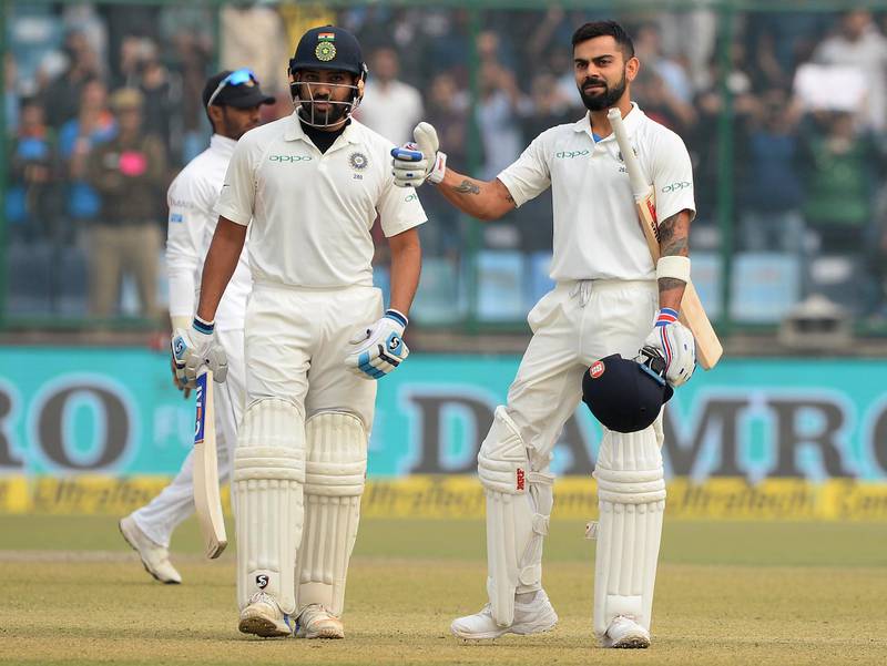 Indian batsman and team captain Virat Kohli (R) celebrates after completes his double century (200 runs) as and Rohit Sharma looks on during the second day of the third Test cricket match between India and Sri Lanka at the Feroz Shah Kotla Cricket Stadium in New Delhi on December 3, 2017. (Photo by SAJJAD HUSSAIN / AFP) / ----IMAGE RESTRICTED TO EDITORIAL USE - STRICTLY NO COMMERCIAL USE----- / GETTYOUT