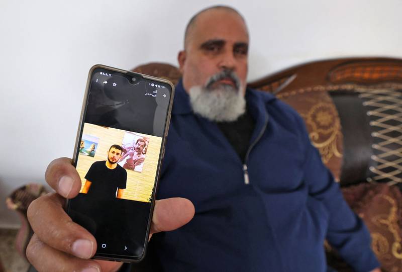 A relative shows a photo of Raad Hazem, 28, a Palestinian from Jenin refugee camp who opened fire in a Tel Aviv bar on April 7, 2022. AFP