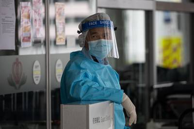 A guard in protective gear stands outside the Accident and Emergency building at Princess Margaret Hospital in Hong Kong, China.  EPA