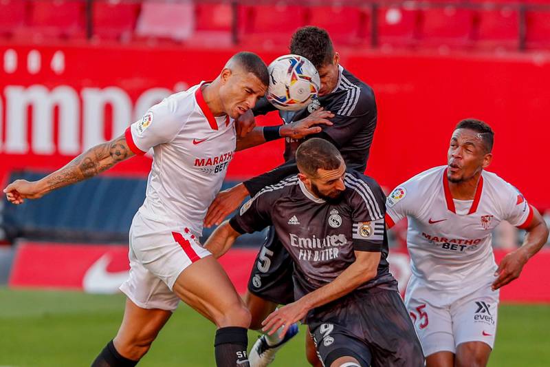 Real Madrid's Karim Benzema, second right, and Raphael Varane centre top, fights for the ball with Sevilla's Fernando and Diego Carlos, left. AP
