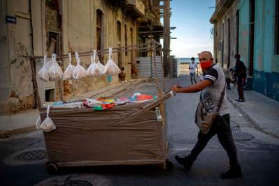 A street vendor pushes his cart down a street in Havana, Cuba. AP Photo