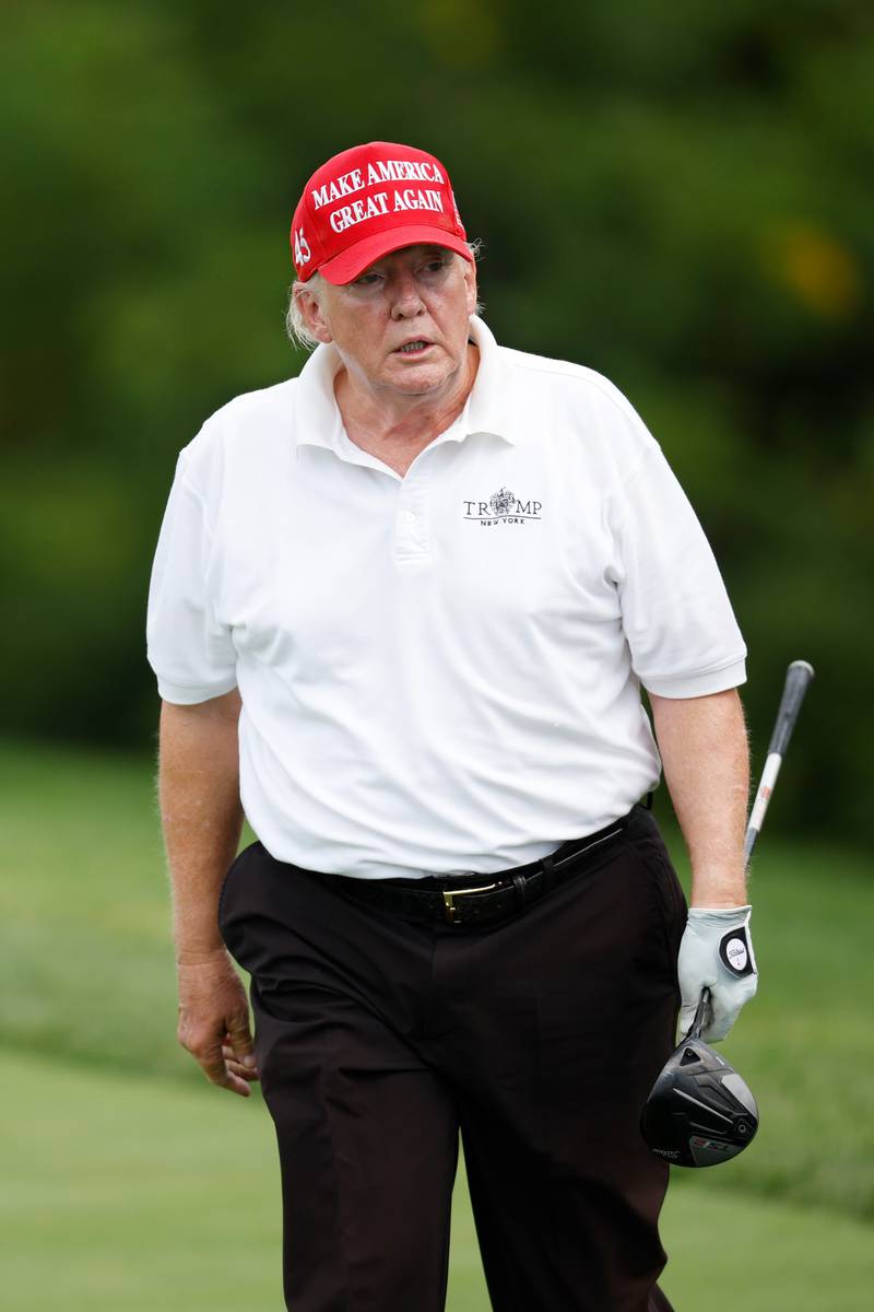 Mr Trump reacts after his shot from the second tee. AFP